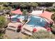 Aerial view of a luxurious pool area with palm trees, lounge chairs, and colorful umbrellas at 13418 W Mayberry Trl, Peoria, AZ 85383