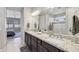 Beautiful bathroom with double sinks, granite countertops, and a view into a bedroom with soothing gray tones at 13418 W Mayberry Trl, Peoria, AZ 85383