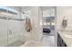 Modern bathroom with a glass shower and bench, leading to a comfortable bedroom for convenience and relaxation at 13418 W Mayberry Trl, Peoria, AZ 85383
