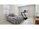 Inviting bedroom with a treadmill, soft gray bedding, and window blinds for a comfortable workout and restful sleep at 13418 W Mayberry Trl, Peoria, AZ 85383
