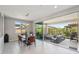 Bright dining area features an elegant glass table, stylish lighting, and seamless transition to a cozy outdoor living space at 13418 W Mayberry Trl, Peoria, AZ 85383
