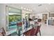 Elegant dining room with glass table, stylish chairs, modern lighting, and seamless flow to the living area at 13418 W Mayberry Trl, Peoria, AZ 85383