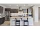 Open concept kitchen with a granite island, stainless steel appliances, dark cabinets, and bar stool seating at 13418 W Mayberry Trl, Peoria, AZ 85383