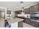 Modern kitchen featuring stainless steel appliances, dark cabinetry, and a granite-topped island with bar stool seating at 13418 W Mayberry Trl, Peoria, AZ 85383