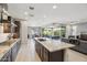 Spacious open-concept kitchen with stainless steel appliances, granite island, and seamless flow to the living area at 13418 W Mayberry Trl, Peoria, AZ 85383