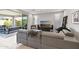 Contemporary living room with neutral tones, modern furniture, a ceiling fan, and sliding glass doors to outdoor space at 13418 W Mayberry Trl, Peoria, AZ 85383