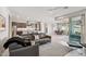 Bright, open living room with modern furniture, recessed lighting, and seamless transition to kitchen and dining area at 13418 W Mayberry Trl, Peoria, AZ 85383