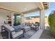 Inviting covered patio with modern furniture and a cozy fireplace, offering a comfortable outdoor living space at 13418 W Mayberry Trl, Peoria, AZ 85383
