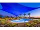 Resort-style pool area with comfortable lounge chairs, umbrellas, and lush landscaping at 13418 W Mayberry Trl, Peoria, AZ 85383