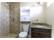 Bathroom featuring granite countertop, built in cabinet, and tiled shower with new shower head at 1518 N Gilbert Ave, Casa Grande, AZ 85122