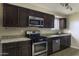 Kitchen with dark cabinets, stainless steel appliances, tile floor and light countertops at 1518 N Gilbert Ave, Casa Grande, AZ 85122