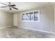 Bright living room featuring large window with shutters, ceiling fan, and neutral color palette at 1518 N Gilbert Ave, Casa Grande, AZ 85122