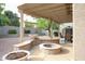 A covered patio features a unique firepit with desert landscaping at 17062 N 184Th Dr, Surprise, AZ 85374