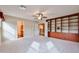 Spacious bedroom featuring carpet, a built-in bookcase, a ceiling fan and access to a bathroom at 17062 N 184Th Dr, Surprise, AZ 85374