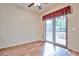 Bright bedroom featuring wood-look flooring, ceiling fan, and glass sliding doors leading to outdoor living space at 17062 N 184Th Dr, Surprise, AZ 85374