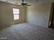 Spacious bedroom featuring neutral walls, carpet flooring, a ceiling fan, and natural light from a window at 17062 N 184Th Dr, Surprise, AZ 85374