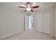 Comfortable bedroom with neutral walls, carpet, a ceiling fan, and a closet with folding doors at 17062 N 184Th Dr, Surprise, AZ 85374
