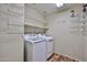 Functional laundry room featuring a washing machine and dryer, shelving, and tiled floors at 17062 N 184Th Dr, Surprise, AZ 85374