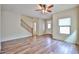 Bright living room with wood-look tile floors, ceiling fan, stairs, and a view of the front door at 17062 N 184Th Dr, Surprise, AZ 85374
