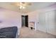 Bedroom with a ceiling fan, two windows, pink walls, a bed, and a view of the door that leads to a hallway at 17916 N 183Rd Ave, Surprise, AZ 85374