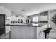 Modern kitchen with white cabinets, stainless steel appliances, and a large breakfast bar with stylish seating at 17916 N 183Rd Ave, Surprise, AZ 85374
