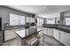 Well-lit kitchen showcasing black countertops, a central island, and mosaic backsplash at 17916 N 183Rd Ave, Surprise, AZ 85374
