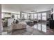 Spacious living room featuring modern furnishings and elegant gray color scheme and view to kitchen and dining area at 17916 N 183Rd Ave, Surprise, AZ 85374