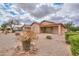 View of the manicured back yard, covered patio and neutral colored home at 188 N Nueva Ln, Casa Grande, AZ 85194