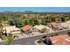 Wide aerial view showcases homes, golf course, and a mountain range in the distance under a blue sky at 19277 N 78Th Ln, Glendale, AZ 85308