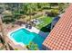 Aerial shot of a backyard featuring a pristine pool, palm trees, green lawn, and outdoor seating area at 19277 N 78Th Ln, Glendale, AZ 85308
