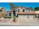Charming two-story home featuring a red tile roof and a three-car garage, set against a clear blue sky at 19277 N 78Th Ln, Glendale, AZ 85308
