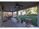 Covered patio with seating, ceiling fans, and views of the lush backyard and pool at 19277 N 78Th Ln, Glendale, AZ 85308