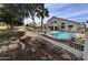 Backyard view showing a pristine pool surrounded by a decorative rock border and wrought iron fencing at 19277 N 78Th Ln, Glendale, AZ 85308