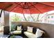 Inviting outdoor patio with comfortable seating under a large red umbrella, perfect for relaxation and entertainment at 20802 N Grayhawk Dr # 1151, Scottsdale, AZ 85255
