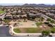 Aerial view of community basketball court surrounded by lush green grass and mountain views at 21030 E Misty Ln, Queen Creek, AZ 85142