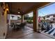 Covered back patio with a ceiling fan, dining area, and comfortable seating, ideal for outdoor dining and relaxation at 21030 E Misty Ln, Queen Creek, AZ 85142