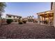 Expansive backyard with a covered patio and low-maintenance gravel landscaping, ideal for outdoor living at 21030 E Misty Ln, Queen Creek, AZ 85142