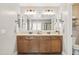 Bathroom featuring a double vanity with two mirrors, stylish lighting fixtures, and ample counter space at 21030 E Misty Ln, Queen Creek, AZ 85142