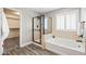 Bright bathroom featuring a glass enclosed shower, soaking tub, and wood look flooring at 21030 E Misty Ln, Queen Creek, AZ 85142