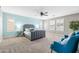 Spacious primary bedroom featuring a gray headboard, soft carpet, and stylish blue accent chairs at 21030 E Misty Ln, Queen Creek, AZ 85142