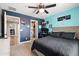 This bedroom offers gamer-themed decor, a ceiling fan, and an attached walk-in closet and bathroom at 21030 E Misty Ln, Queen Creek, AZ 85142