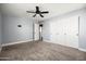 Spacious bedroom featuring plush carpeting, modern ceiling fan, and a closet with sliding doors at 21030 E Misty Ln, Queen Creek, AZ 85142