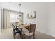 This light-filled dining room includes a rustic table, modern chandelier, and shiplap wall for stylish dining at 21030 E Misty Ln, Queen Creek, AZ 85142