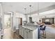 Open kitchen with white cabinetry, granite countertops, stainless appliances and a stunning island with bar stool seating at 21030 E Misty Ln, Queen Creek, AZ 85142