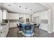 Bright kitchen boasts granite counters, stainless appliances, white cabinetry, and a unique rounded kitchen island at 21030 E Misty Ln, Queen Creek, AZ 85142