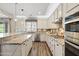 An open, bright kitchen features granite counters, stainless appliances, and stylish backsplash at 21030 E Misty Ln, Queen Creek, AZ 85142