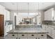 Modern kitchen with granite counters, subway tile, stainless appliances, and breakfast bar overlooking the living area at 21030 E Misty Ln, Queen Creek, AZ 85142