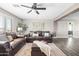 Inviting living room featuring hardwood floors, ceiling fan, and comfortable leather seating at 21030 E Misty Ln, Queen Creek, AZ 85142