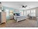 Bright main bedroom with light blue accent wall, white furnishings, carpet, and plantation shutters at 21030 E Misty Ln, Queen Creek, AZ 85142