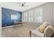 Bright office space features a desk, custom blue accent wall, ceiling fan, and three windows with white shutters at 21030 E Misty Ln, Queen Creek, AZ 85142